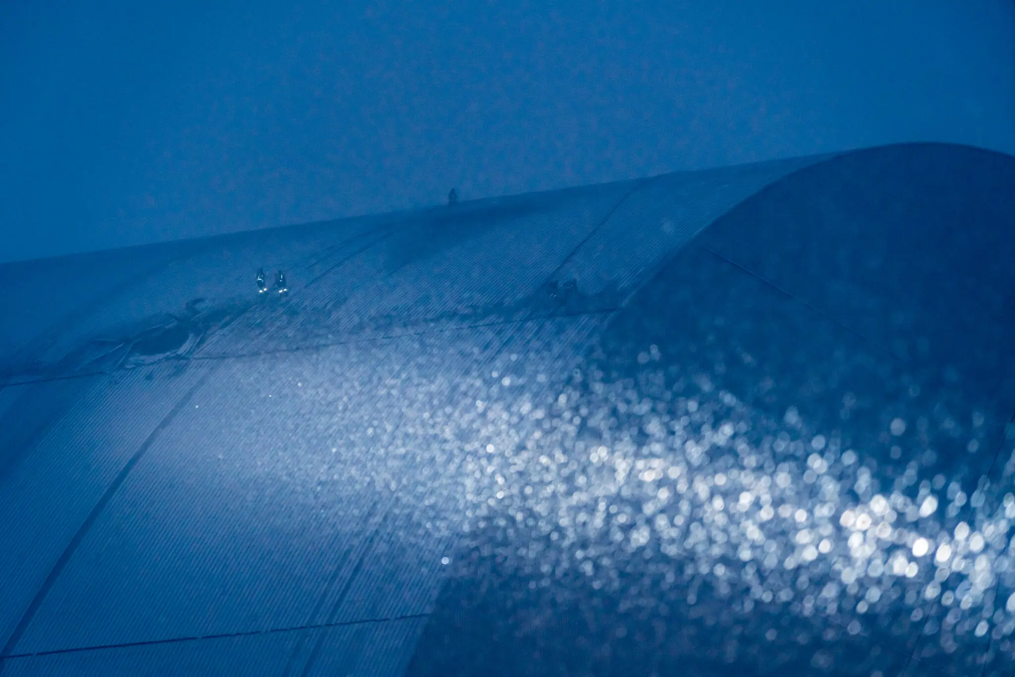 Бійці українського підрозділу протиповітряної оборони освітлюють дірку, яка видна в обгороджувальній конструкції.